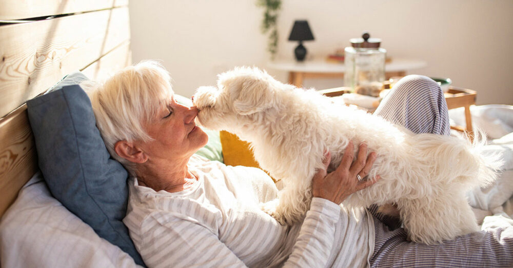Senior woman enjoys time with her dog in her pet friendly senior living apartment.