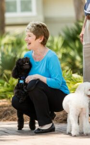A retirement community resident hugs her dog.