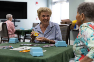 A lady smiles at her partner as they play a game of bridge
