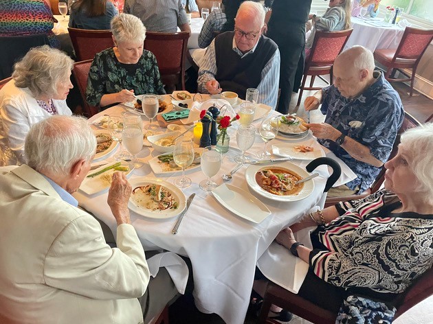 A group of older people eating at a table.